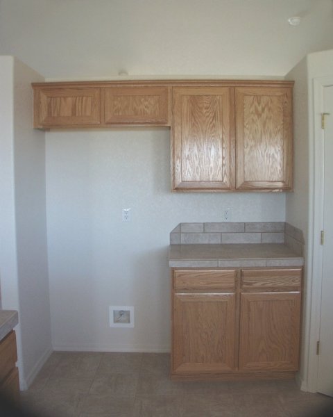 Kitchen - where refrigerator goes / Oak cabinets / corner of pantry on right side / pot shelf above these cabinets & pantry